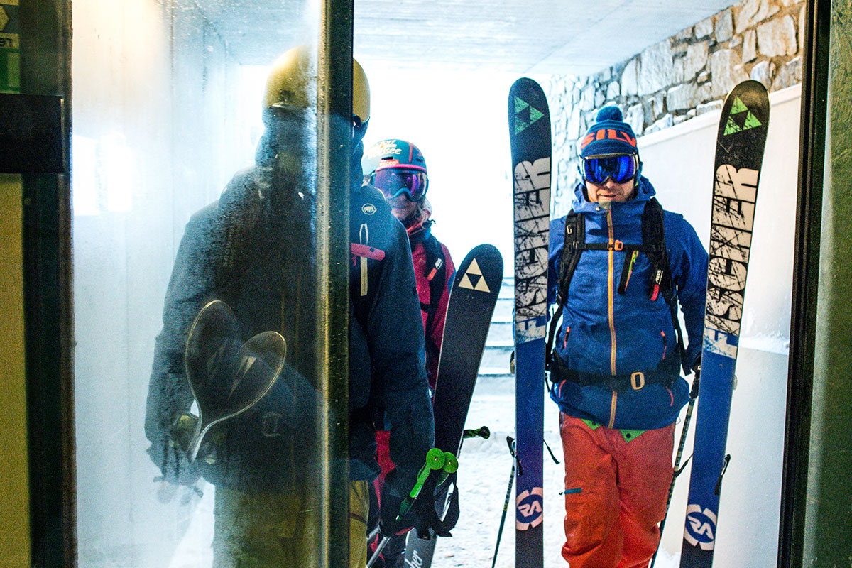 Gruppe Freeski-Fahrer mit Skiern am Eingang eines Gebäudes